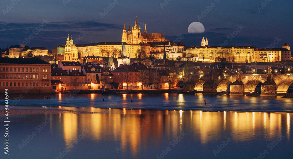 Panorama night view of prague castle and st. vitus and cathedral bridge on ece vltava at night in the center of prague and super moon at sky