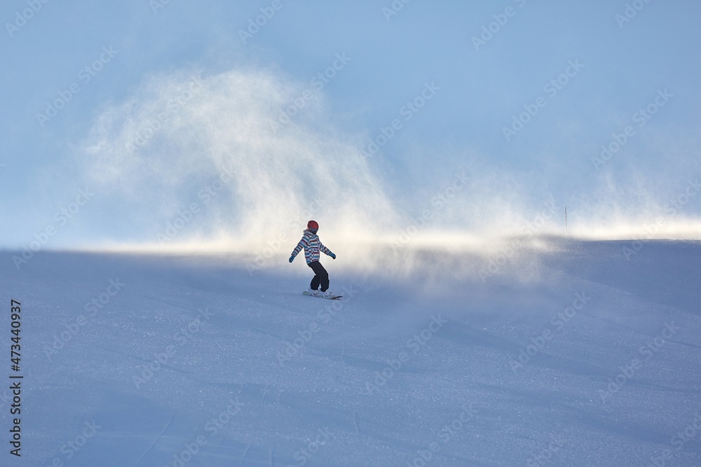 Female snowboarder fast on a slope