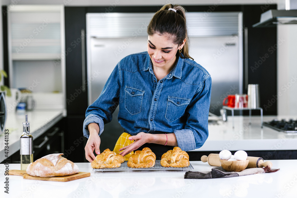 young Latin woman baking croissant ingredients in kitchen in Mexico Latin America
