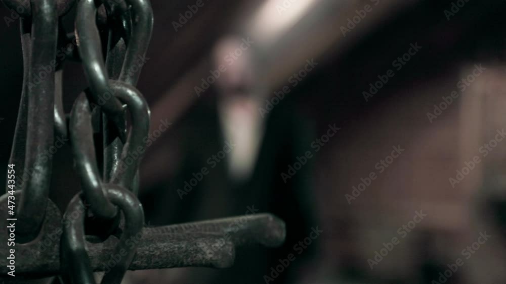 Abstract dark chain hanging, close up. Dark background, fixed Abstract dark chain hanging, close up. Dark background, fixed