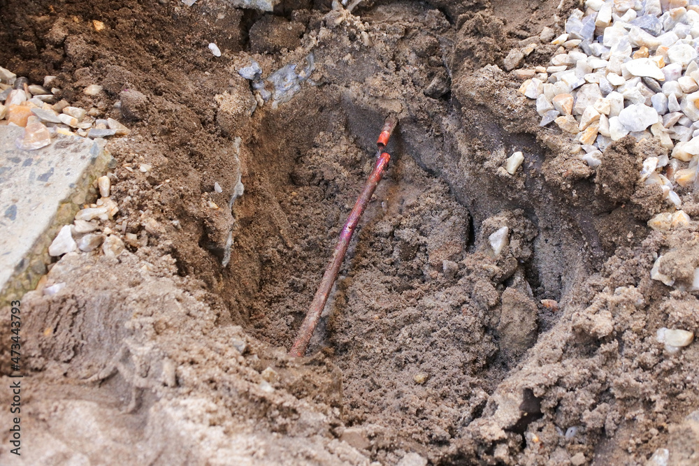 Hole in the ground with underground water pipe leak Hole in the ground with underground water pipe leak