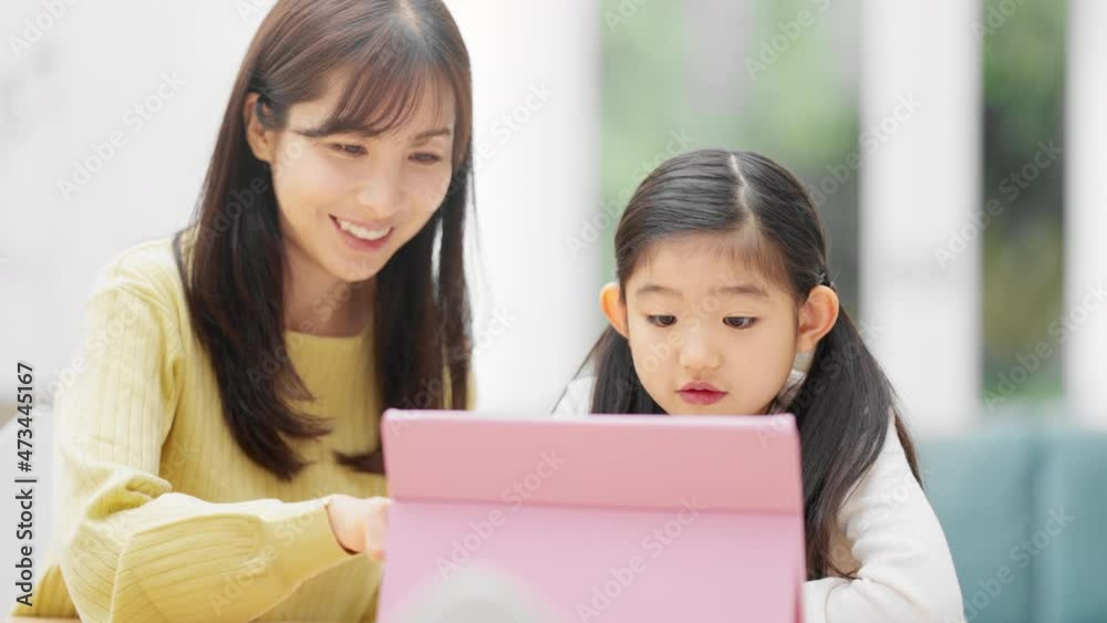 タブレットパソコンで勉強する女の子とその母親 タブレットパソコンで勉強する女の子とその母親