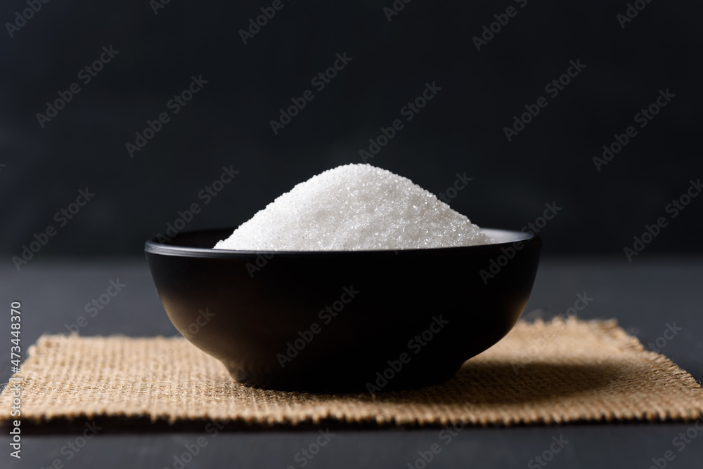 White granulated sugar on black background