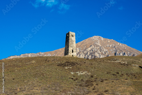 Ancient stone tower on the background of blue mountains