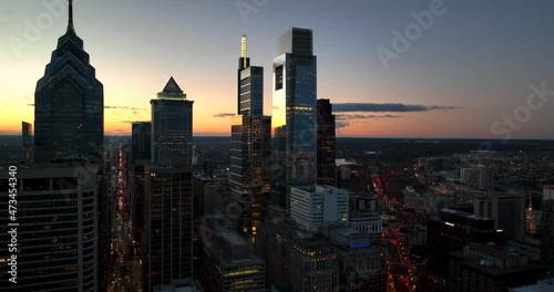 Silhouettes of office building towers at sunset. Traffic in street below. Aerial slo-mo view, dramatic silhouette. photo