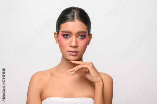 The woman put on pink makeup and put her hand on her chin.