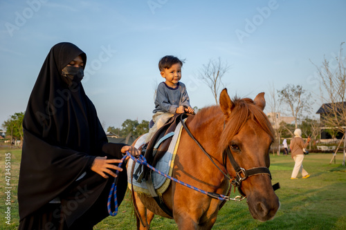Asian boy practicing horseback riding in childcare center