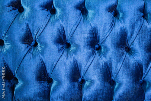 Blue velvet capitone textile, suede, velor, with buttons, sofa back. Close up texture
