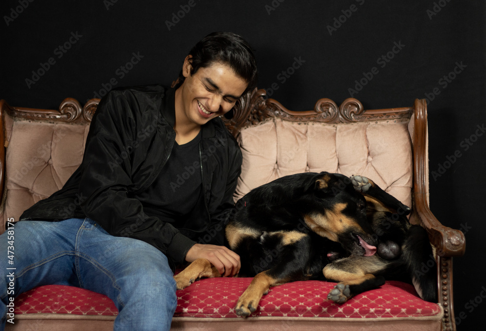 Obraz premium boy laughing in amusement because his dog is licking his privates
