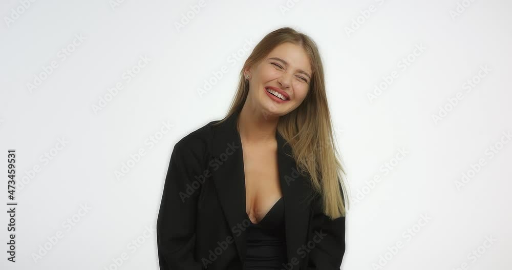 Beautiful young woman with long blond hair laughs. Young caucasian woman in a black shirt smiling in the studio on a white background. Beautiful young woman with long blond hair laughs. Young caucasian woman in a black shirt smiling in the studio on a white background.