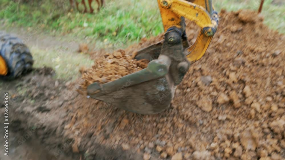 Mini excavator digs a trench to lay pipes.