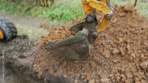 Mini excavator digs a trench to lay pipes.