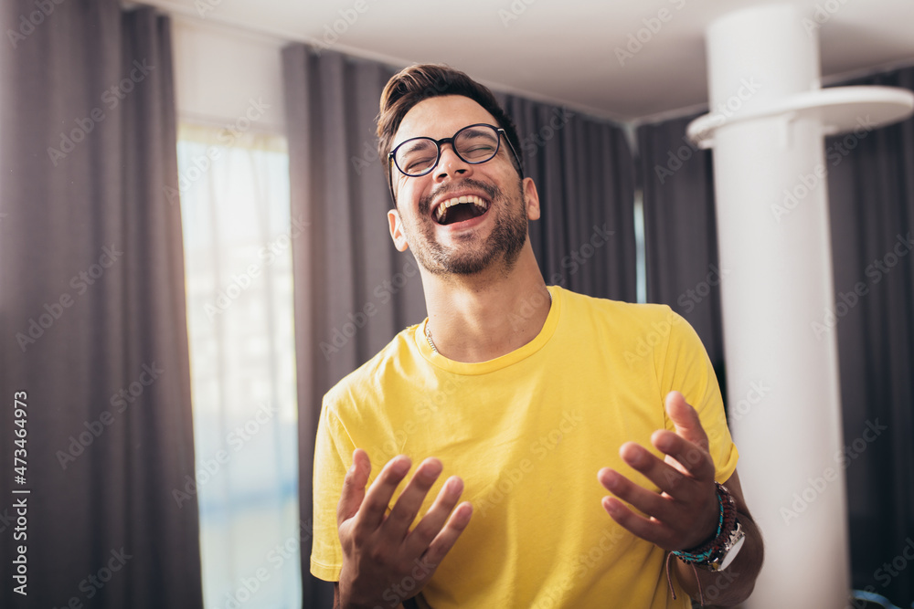 Portrait smart confident smiling millennial man standing at home Portrait smart confident smiling millennial man standing at home