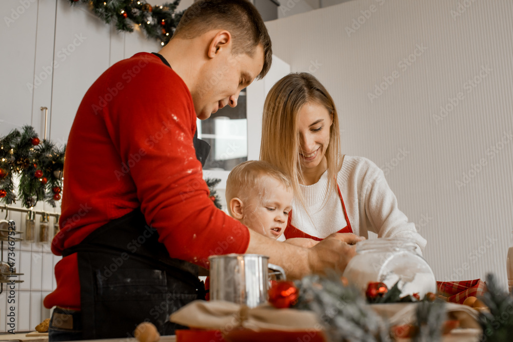 Side view of happy funny family mother, father and little son bake christmas cookies on cozy kitchen at home