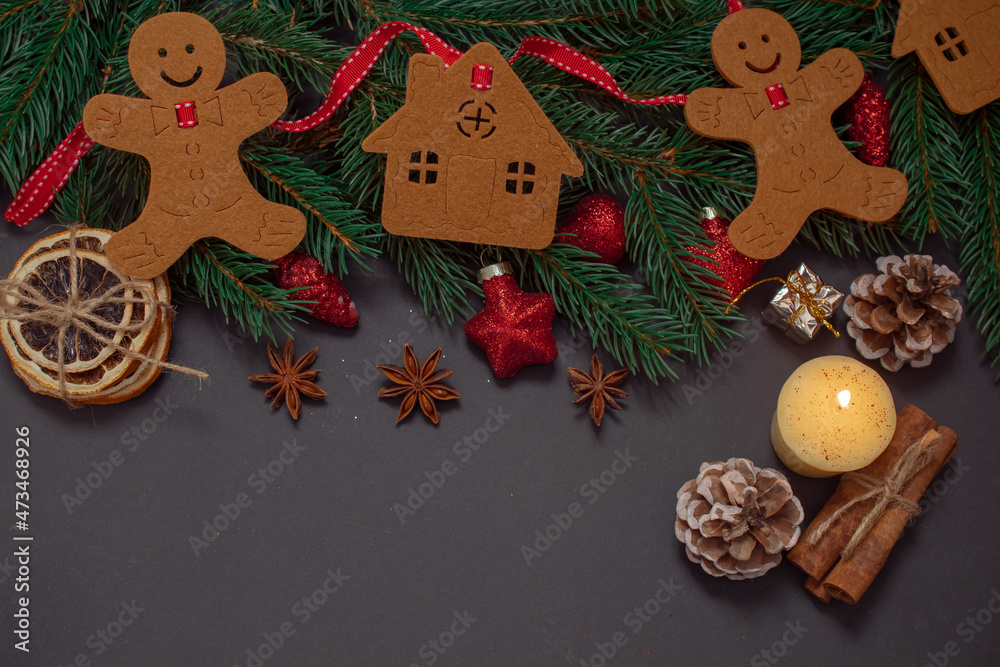 Winter background with Christmas tree branches, cones, Christmas toys and Christmas cookies, with black space for replicas