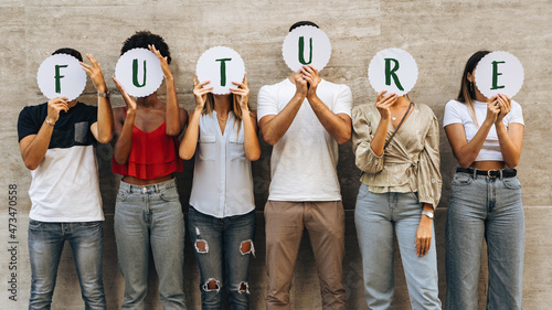 Young people hiding faces behind the word 'Future' - Concerns and prospects for new generations - Concept of youth questioning their future. photo
