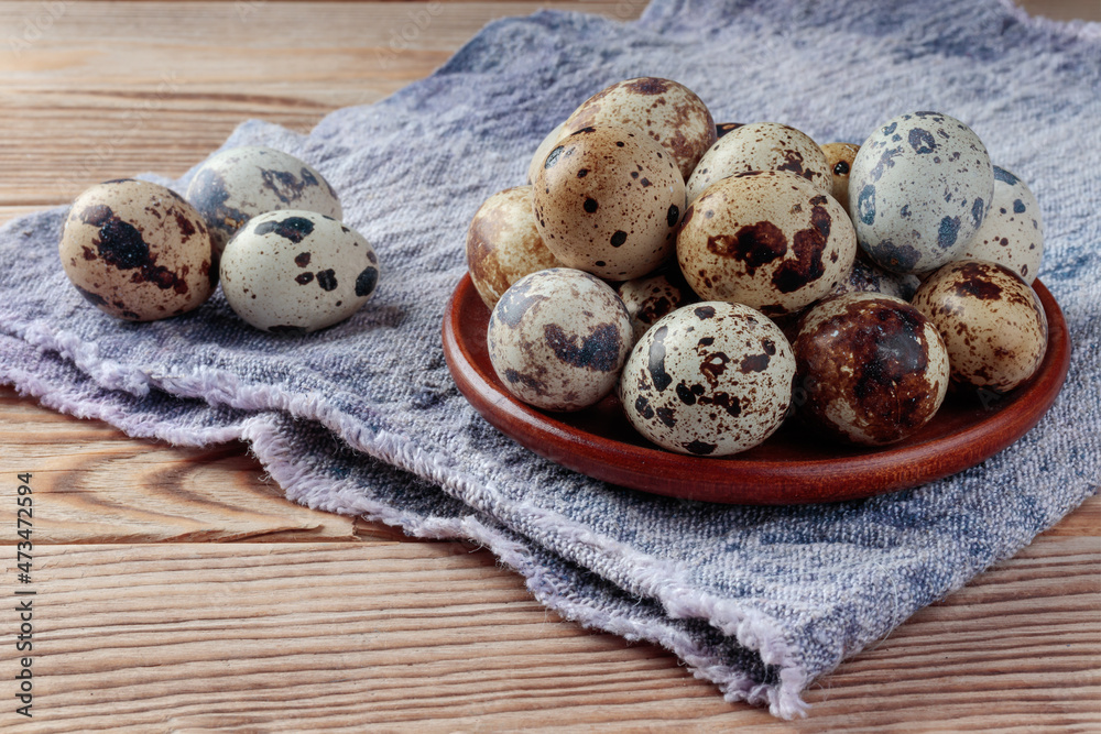 Top view of Quail eggs in wooden plate on wooden background. Selective focus. Top view of Quail eggs in wooden plate on wooden background. Selective focus.