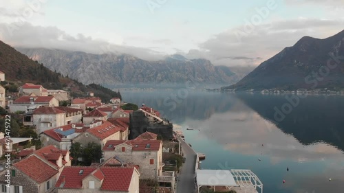 Fly over the red rooftops of Perast towards the majestic mountains