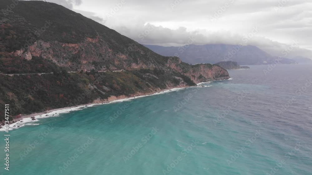 Panoramic views of the sea, mountains and clouds, waves hitting the rocks Panoramic views of the sea, mountains and clouds, waves hitting the rocks