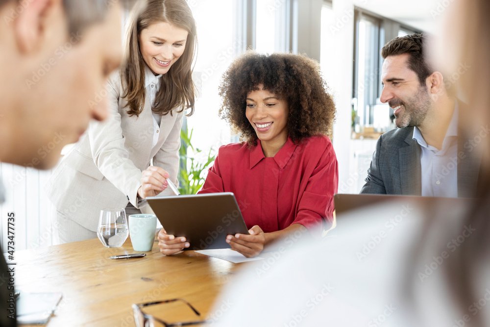 Businesswoman using digital tablet with colleague in meeting at office Businesswoman using digital tablet with colleague in meeting at office