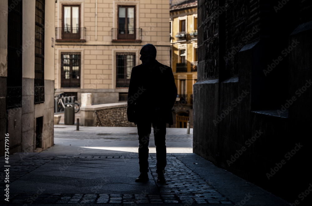 Silhouette of adult man on a narrow street of city. Shot in Madrid, Spain