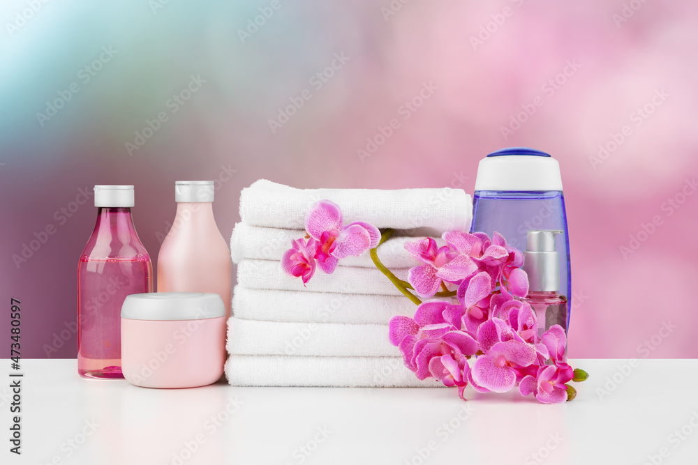 Towels with flowers on light table against blurred background