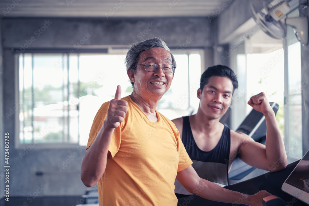 Senior man and trainer man working out on exercise running on treadmill in gym center Senior man and trainer man working out on exercise running on treadmill in gym center