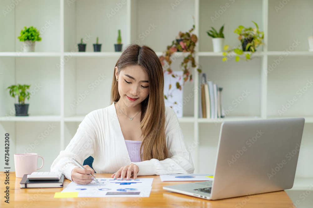 Freelance Asian woman working on tablet computers and financial graphs in a modern office. make an account analysis report real estate investment information financial and tax system concepts Freelance Asian woman working on tablet computers and financial graphs in a modern office. make an account analysis report real estate investment information financial and tax system concepts