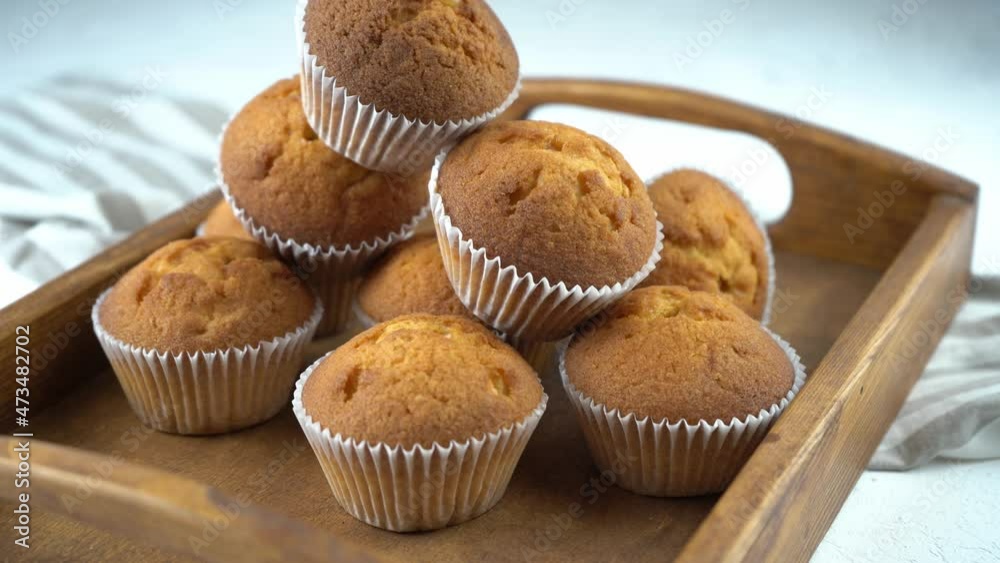 Muffins - delicious pastries. Baked dessert on the tabletop view. Homemade muffin. Portioned cupcakes. Simple food for party. Close-up muffins on a wooden tray. Muffins - delicious pastries. Baked dessert on the tabletop view. Homemade muffin. Portioned cupcakes. Simple food for party. Close-up muffins on a wooden tray.