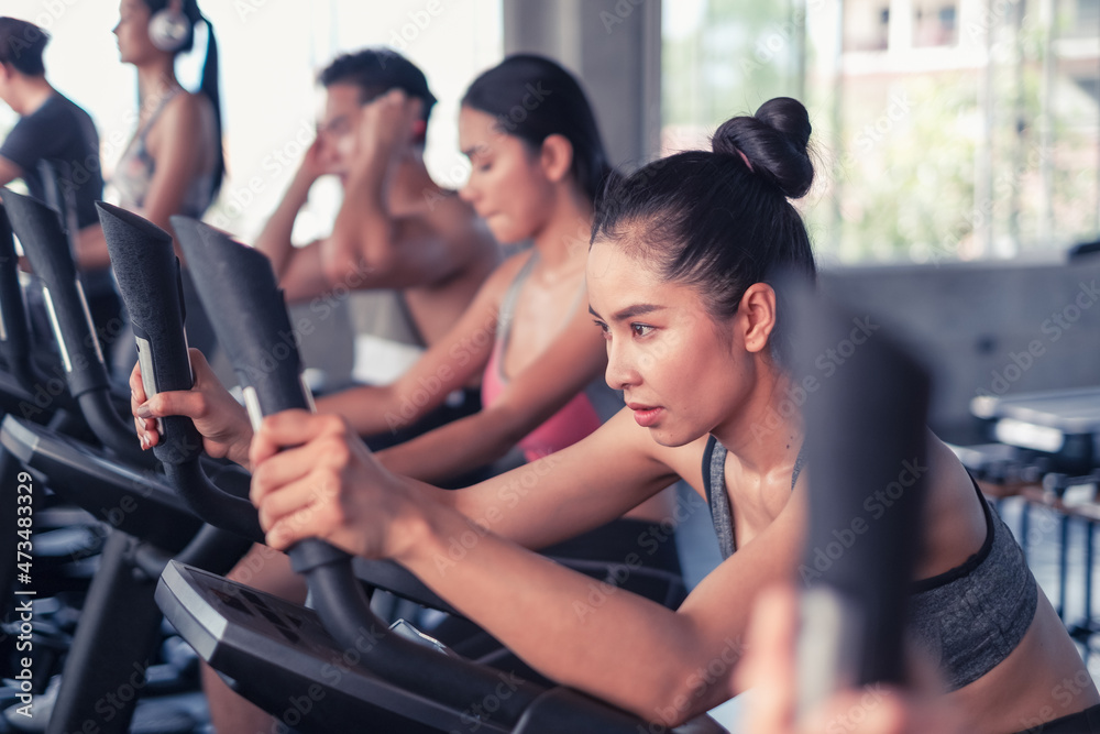 group friends working out on exercise bike and wearing sportswear in fitness or gym center, strength sporty and weight loss concept group friends working out on exercise bike and wearing sportswear in fitness or gym center, strength sporty and weight loss concept