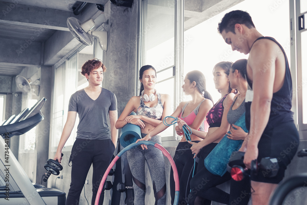 Smiling group of asia friends, happy young women and men relax together after a workout at gym center, Strength sporty and weight loss concept Smiling group of asia friends, happy young women and men relax together after a workout at gym center, Strength sporty and weight loss concept