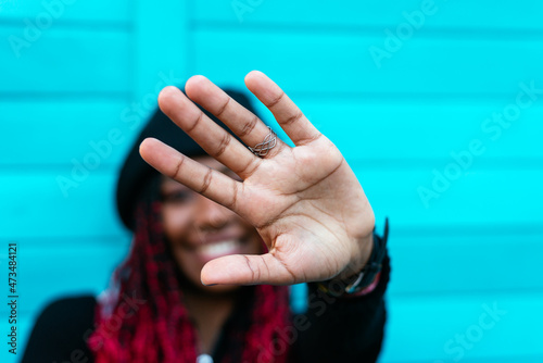 Glad ethnic woman showing stop gesture