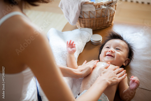 赤ちゃんの肌に保湿クリームを塗る母親 photo