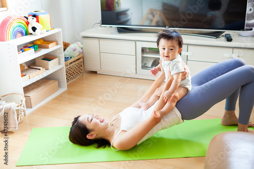 赤ちゃんと一緒にヨガをする若い母親
