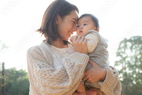 公園で赤ちゃんを抱っこするお母さん photo