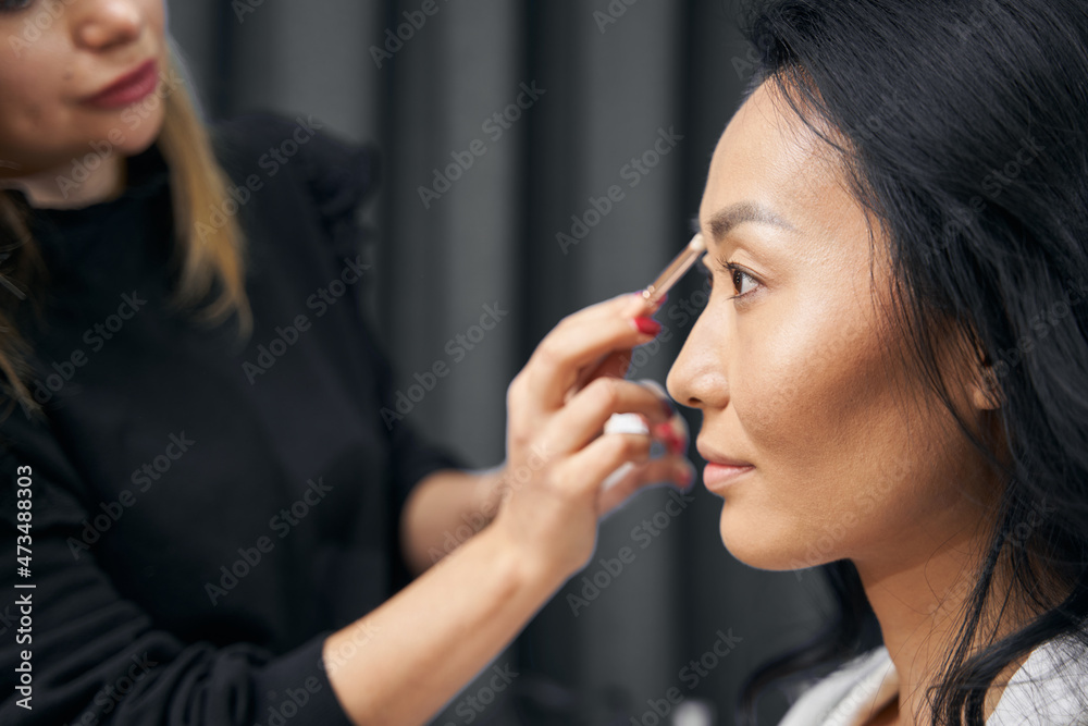 Charming attractive female receiving professional visage in modern bright salon Charming attractive female receiving professional visage in modern bright salon