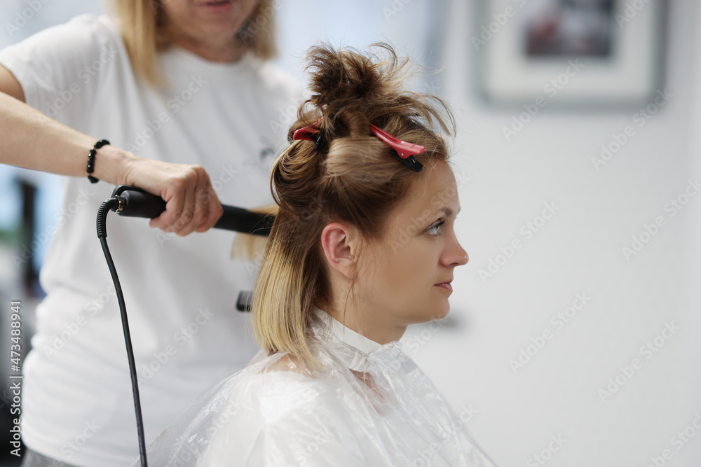 Naklejka premium Blonde woman on planned hairdresser appointment enjoy new image in mirror
