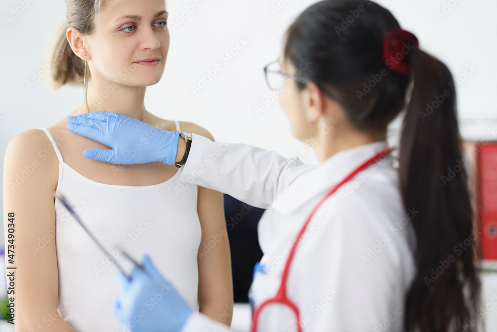 Blonde female on doctors appointment being examined by professional medical worker Blonde female on doctors appointment being examined by professional medical worker
