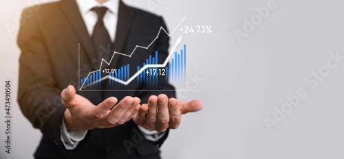 Businessman holding graph growth and increase of chart positive indicators in his business.Investment up concept.analyzing sales data and economic,strategy and planning, Digital marketing and stock 