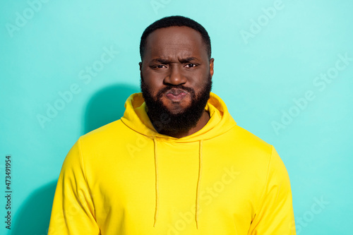 Photo of brunette sad millennial guy wear yellow sports cloth isolated on turquoise color background