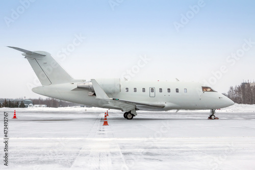 White luxury corporate business jet on the winter airport apron