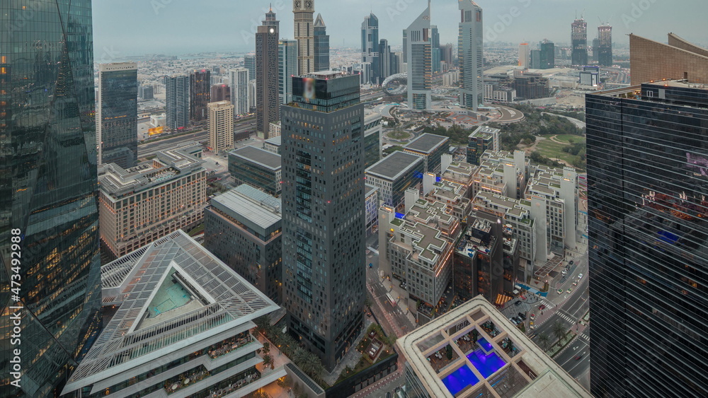 Obraz premium Panorama of futuristic skyscrapers after sunset in financial district business center in Dubai day to night timelapse