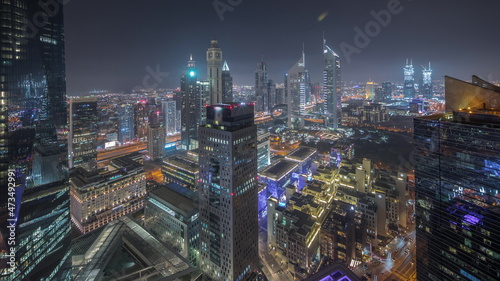 Fototapeta Panorama of futuristic skyscrapers in financial district business center in Dubai night timelapse