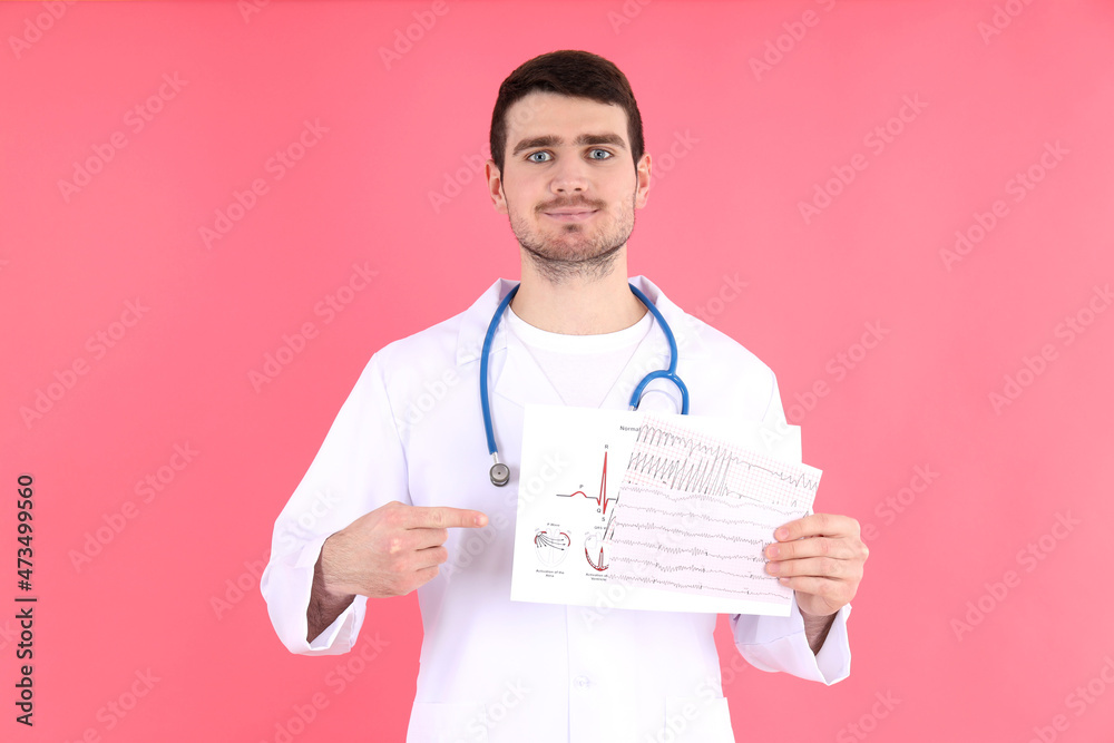 Doctor - intern with cardiogram on pink background Doctor - intern with cardiogram on pink background