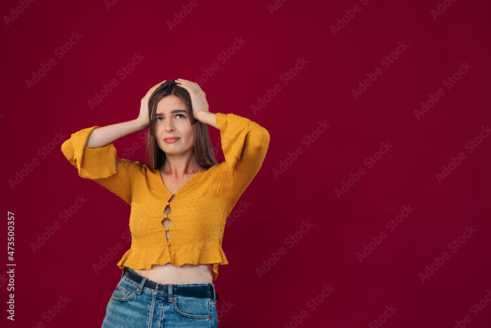 Young beautiful woman wearing yellow blouse hold to the head depressed and worried about distress crying. Sad expression. Young beautiful woman wearing yellow blouse hold to the head depressed and worried about distress crying. Sad expression.