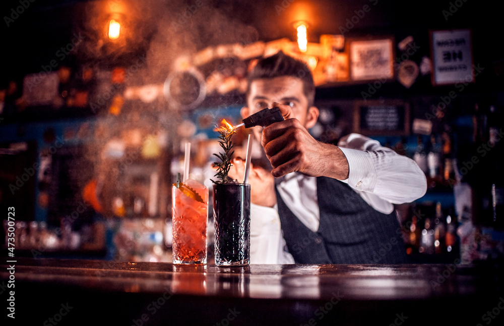 Professional Female bartender intensely finishes his creation at the nightclub