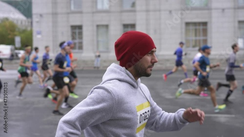 Athletes crowd on marathon sport event, running competition. Groups of racers, marathoners and runners during active lifestyle occasion. Firm build sportsman efforts on triathlon athletics festival. photo