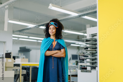 Businesswoman in superhero costume standing in industry photo