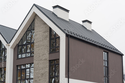 Foto Newly installed construction frame house rain gutter system and chimney pipe on the metal roof top
