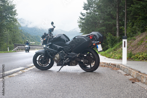 motorcycle on the side of a rural mountain alpine road